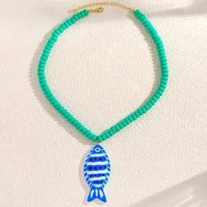 Vue détaillée du collier de perles de style marin avec pendentif poisson tropical bleu