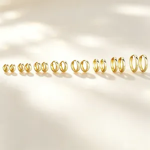 Minimalist gold-plated hoop earrings in multiple sizes arranged on a bright background