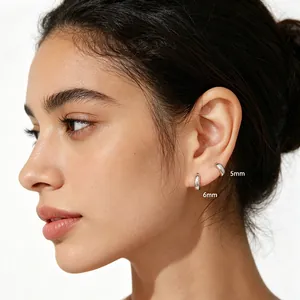 Close-up view of minimalist 925 silver hoop earrings in 5mm and 6mm sizes worn on ear