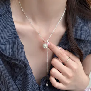 Detail view of a minimalist silver Y-shaped necklace with a pearl popcorn cluster