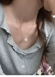 Close-up of a silver popcorn pendant necklace on a model showing fine textures.