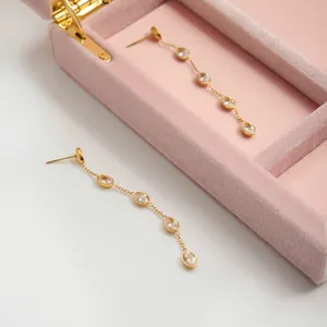 Elegant gold-tone stainless steel tassel earrings featuring clear oval cubic zirconia stones