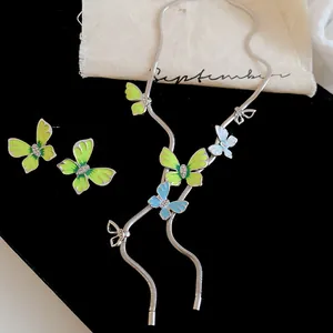 Detailed close-up view of a green rhinestone enamel butterfly jewelry set on velvet