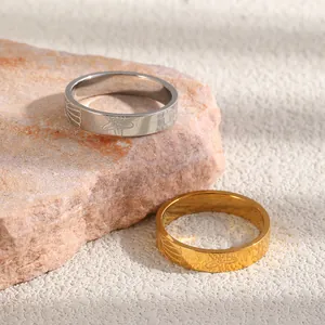 Close-up of stainless steel rings with engraved starfish patterns in gold and silver