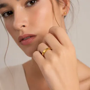 Close-up of minimalist 18K gold-plated stainless steel ring with marine life engraving
