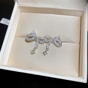 Detailed macro view of silver bow stud earrings with sparkling zircons in a jewelry box