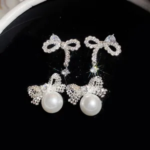 Detailed macro shot of elegant silver bow earrings with zircon and pearls