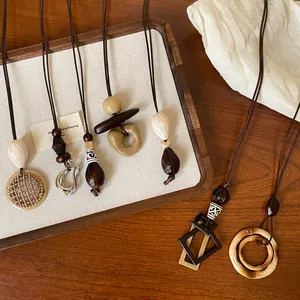 Macro detail of various geometric resin pendants and woven cords on a wooden surface