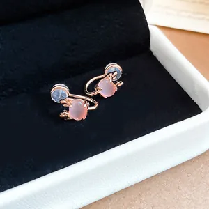 Detailed view of pink cat eye stone clip-on earrings with elegant rose gold antler frames