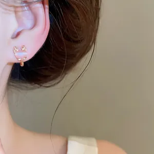 Detailed close-up of cute pink cat's eye stone deer antler ear clip on a female model's ear