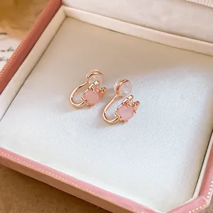 Close-up of cute pink cat eye stone oval clip-on earrings in a pink jewelry box