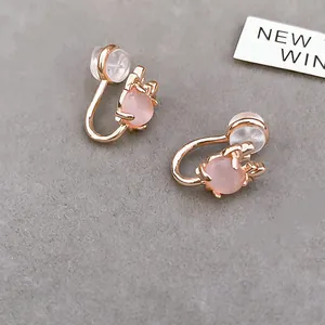 Elegant macro detail of pink cat eye stone clip-on earrings in polished rose gold finish
