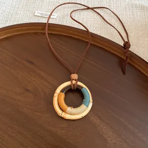 Detailansicht einer ethnischen Holz-Halskette mit farbiger Fadenumwicklung im Mori-Stil