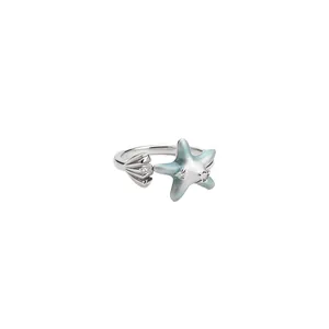 Silver open ring featuring blue enamel starfish and shell with sparkling crystals