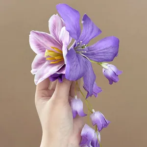 Detailopname van een handgemaakte paarse stoffen bloemenhaarspeld met zachte blaadjes