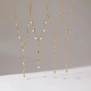 Dettaglio di quattro eleganti collane a Y dorate con pendenti in cristallo lucido.