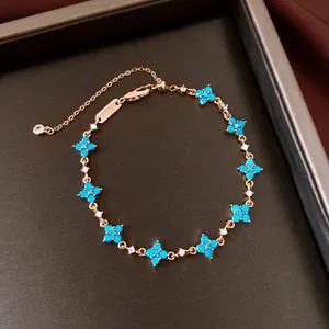 Close-up of 18k gold-plated bracelet with turquoise-blue flower charms and zircons
