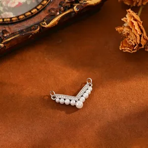 Detail of a vintage-style V-shaped copper pendant with cubic zirconia and faux pearls