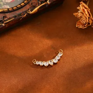 Detailed view of curved gold-plated pendant with sparkling pear and round cubic zirconia.