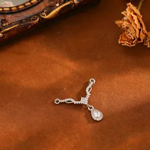 Detail view of a V-shaped copper pendant with a sparkling pear-cut zircon drop