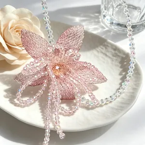 Detailed macro view of pink mesh flower necklace with shimmering iridescent beads.