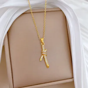 Detailopname van een elegante gouden titanium stalen ketting met een kristallen knoop hanger.