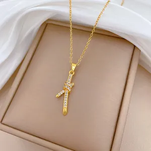 Detailweergave van een gouden knoop hanger ketting bezet met fonkelende kristallen
