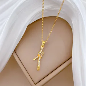 Elegante goudkleurige titanium stalen ketting met een kristallen knoop hanger.
