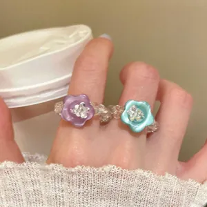 Detailed view of a sweet dopamine style beaded ring featuring purple and blue resin flowers.