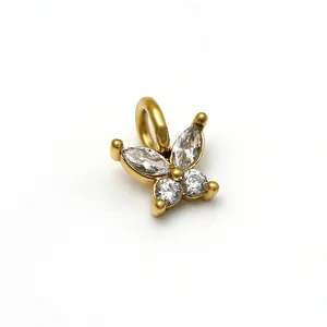 Vue macro d'un pendentif papillon doré avec des zircons marquises et ronds brillants.