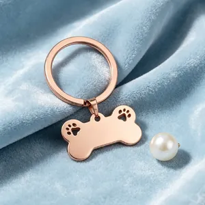 Dettaglio del portachiavi a forma di osso di cane in oro rosa su velluto blu chiaro