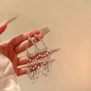 Detailed close-up of long crystal tassel earrings featuring sparkling rhinestones and pearls
