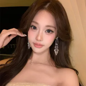 Close-up of elegant long crystal tassel statement earrings for a glamorous goddess look.
