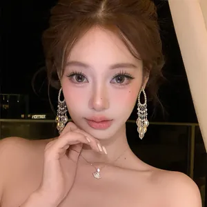 Close-up detail of goddess crystal tassel earrings on model with night background