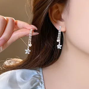 Detail view of elegant silver flower pearl zircon tassel earrings on an Asian model