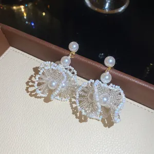 Détail de boucles d'oreilles artisanales françaises en dentelle de perles et cristaux