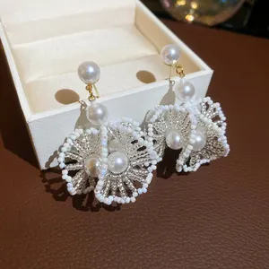 Vue détaillée de boucles d'oreilles fleur en perles et cristaux irisés français