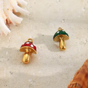 Macro view of red and green mushroom charms made of gold plated stainless steel.