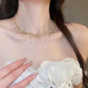 Elegant gold tassel choker necklace with sparkling crystals on a female model.