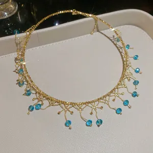 Close-up of a vintage gold choker with light blue crystal fringe tassels