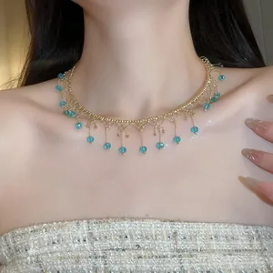 Exquisite close-up of a gold choker featuring elegant blue crystal fringe on a model