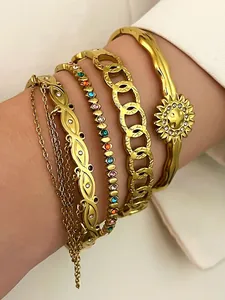 Close-up of stacked bohemian gold-plated stainless steel bracelets with sun charm
