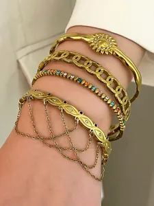 Detail view of four layered gold bohemian stainless steel bracelets with rhinestones.
