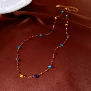Elegant handmade irregular colorful crystal bead gold necklace on dark brown fabric background