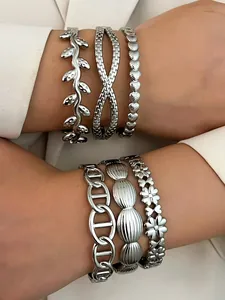 Close-up of stacked silver stainless steel bracelets with leaf, flower and chain designs