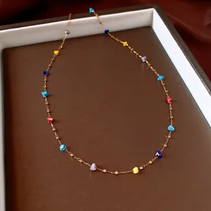 Delicate gold chain necklace with colorful irregular crystal beads in a luxury display tray