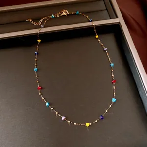 Macro view of colorful irregular crystal beads on a delicate gold chain necklace