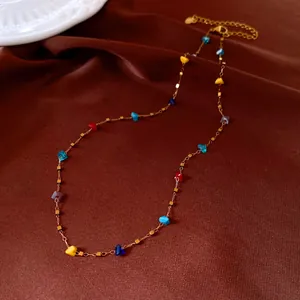 Detail showing vibrant irregular crystal beads on a delicate gold-toned necklace chain