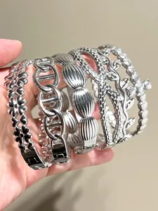 Close-up of stacked bohemian stainless steel bangles in diverse vintage designs.