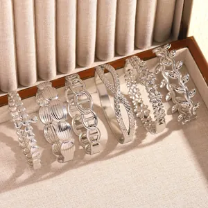 Detailed view of vintage stainless steel bangles with floral and geometric designs